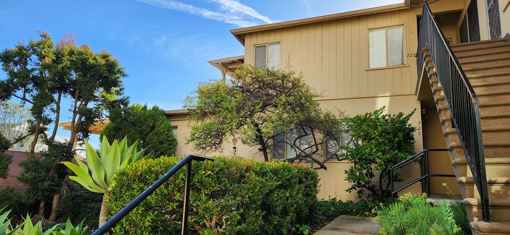 a house with a staircase and a garden in front of it