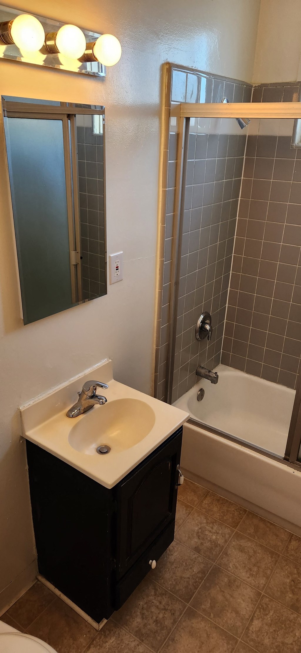 a bathroom with a sink and a tub and a mirror