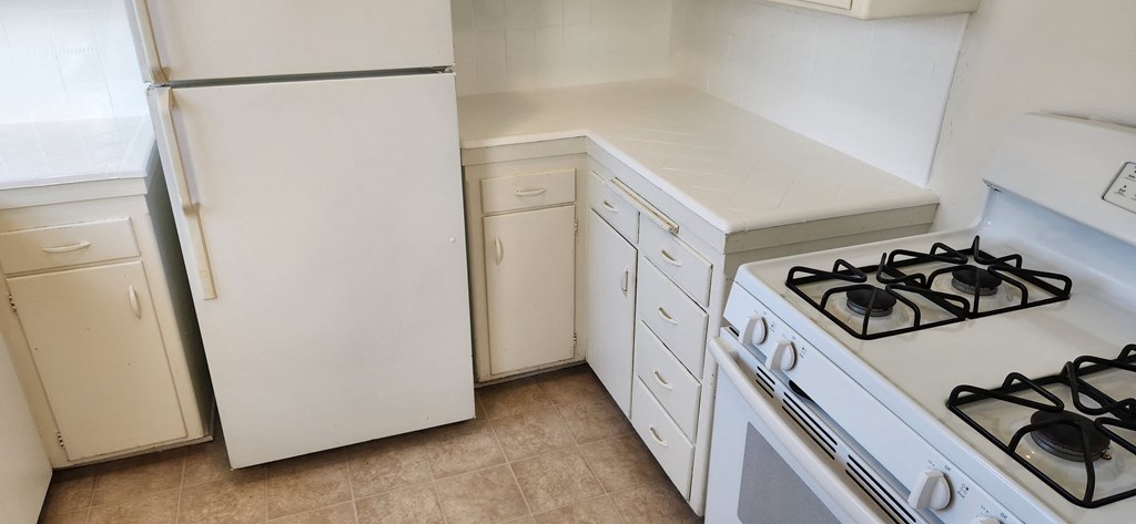an empty kitchen with a stove and a refrigerator
