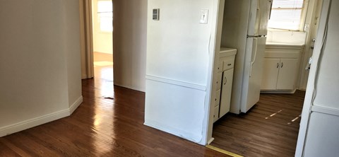 a kitchen with a white refrigerator and a wooden floor