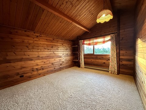 the interior of a log cabin with a carpeted floor
