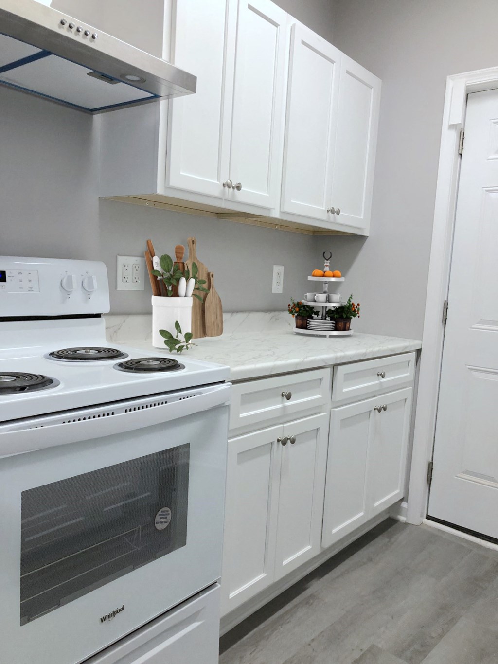 a kitchen with white cabinets and a stove top oven and a sink