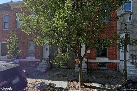 a tree in front of a red brick building