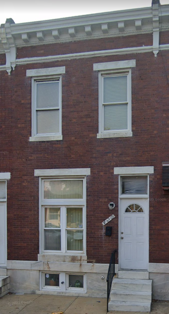 the front of a brick building with a white door