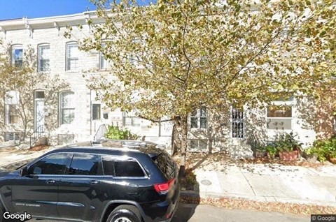 a black car parked in front of a white building