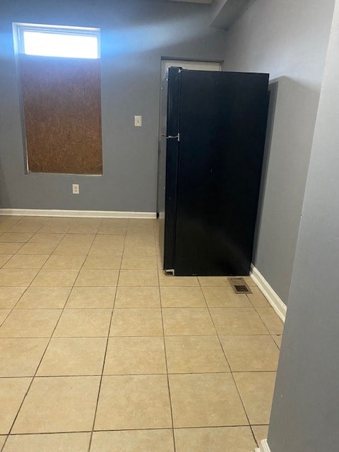 a bathroom with a black door and a tiled floor