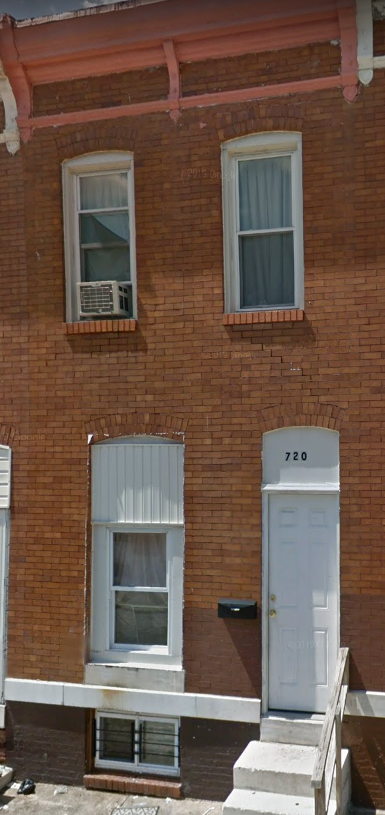 a red brick building with a white door and windows