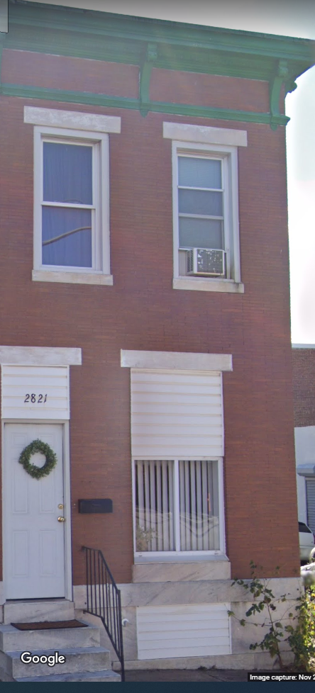a red brick house with a white door and a wreath