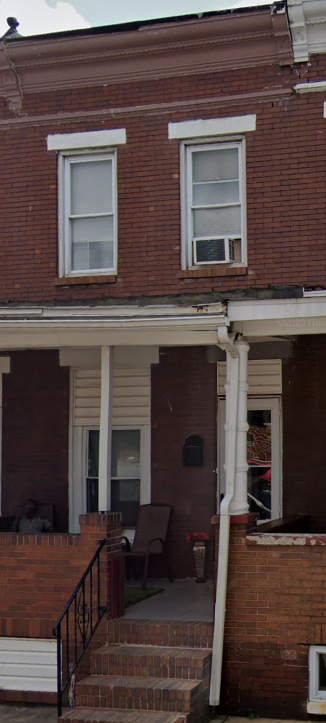 the front of a brick house with two windows