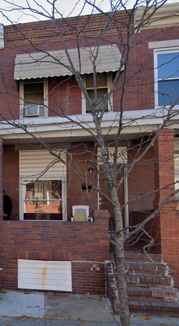 a brick house with a tree in front of it
