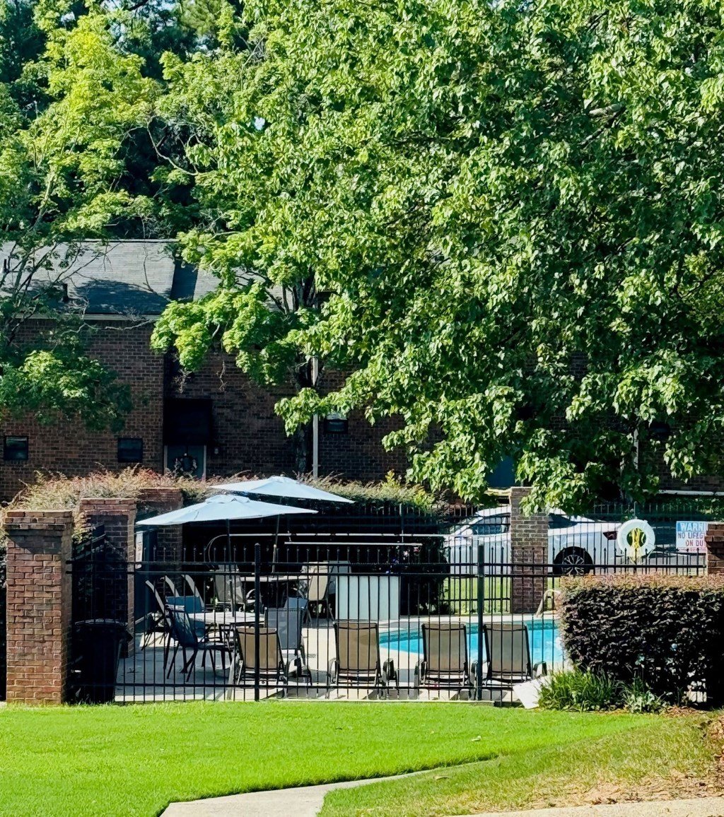 A pool area with a table and chairs under a canopy.