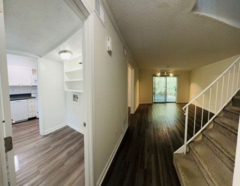 a view of a living room and kitchen from the top of the stairs