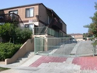 a house with stairs and a fence in front of it