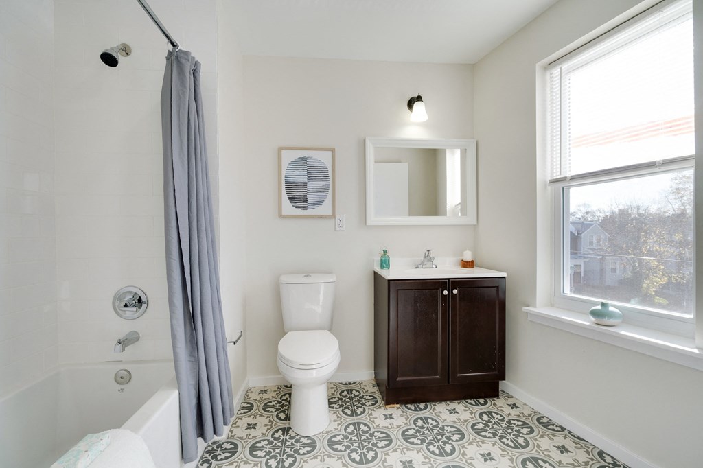 a bathroom with a toilet and a sink and a window