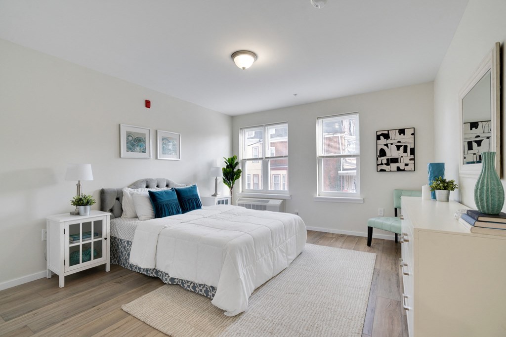 an open bedroom with a bed and a desk with a mirror