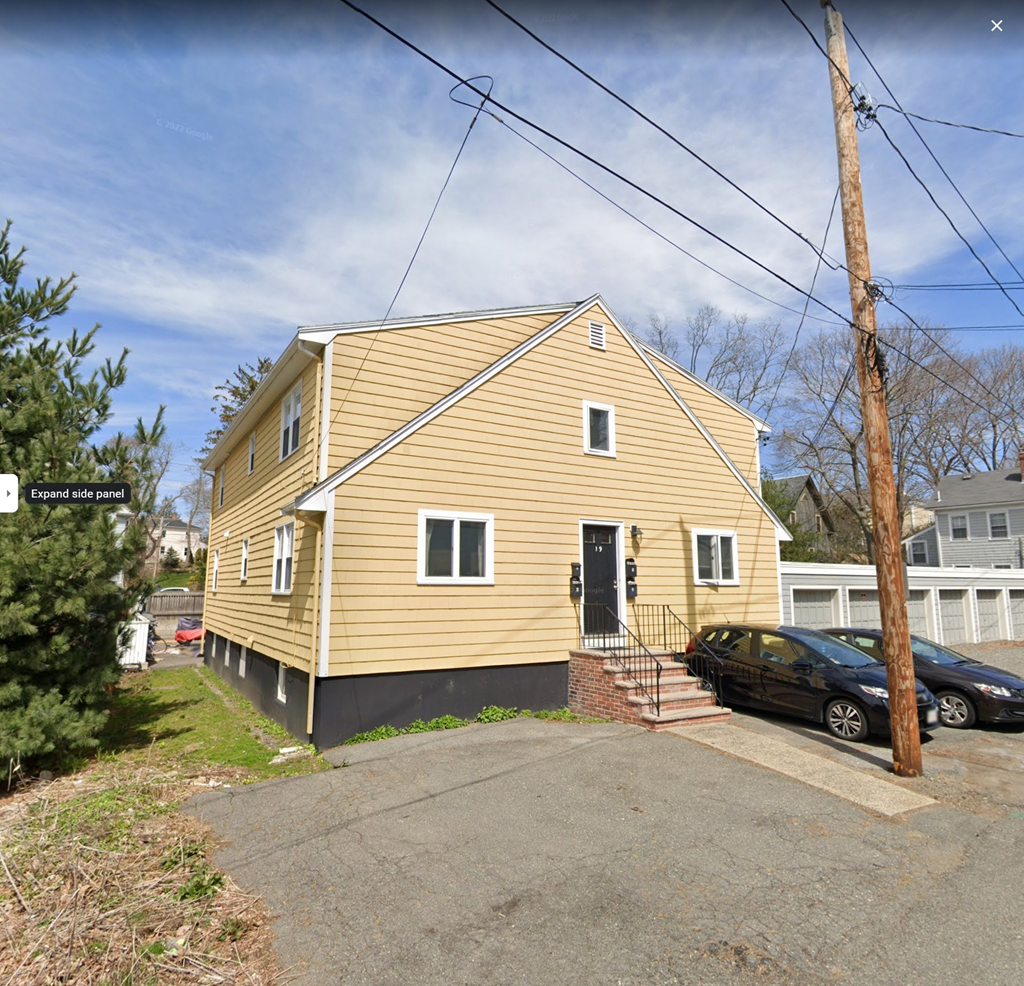 a yellow house with a car parked in front of it