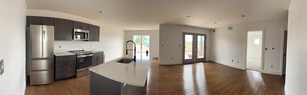 a kitchen with a large island and a stainless steel refrigerator