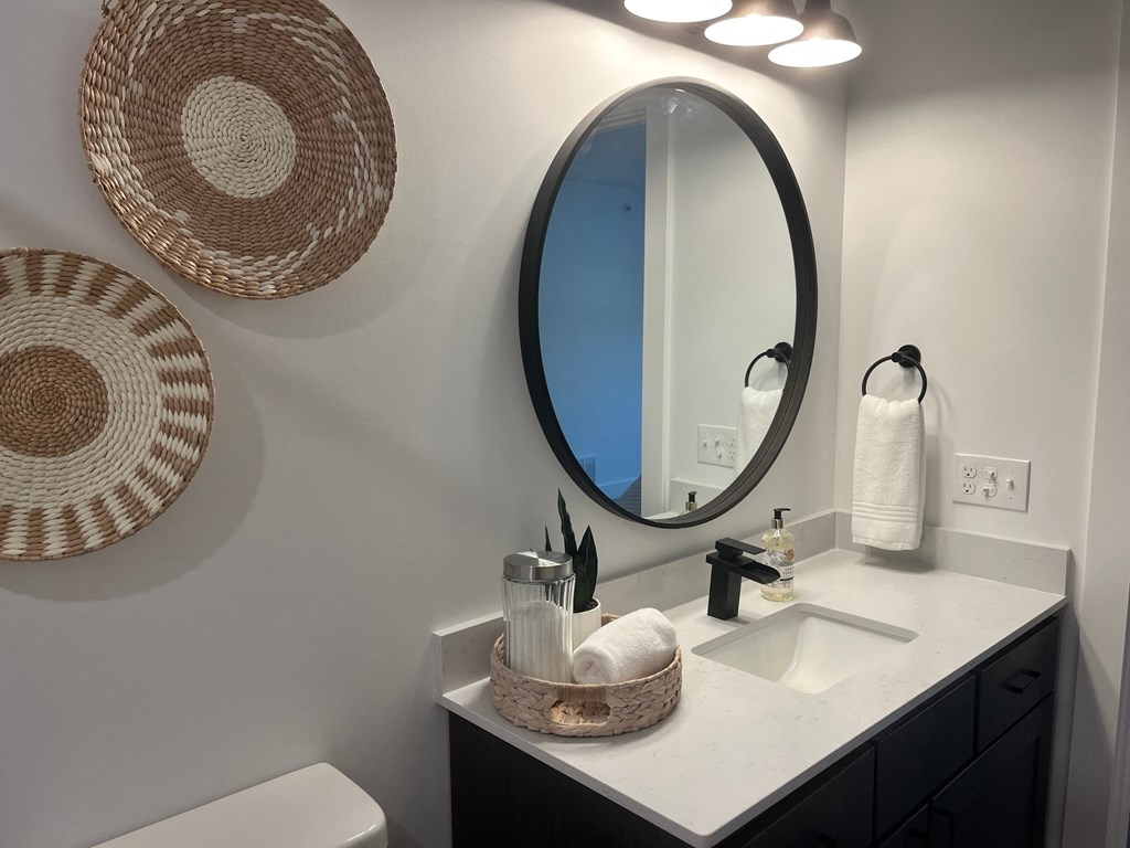 a bathroom with a sink and a mirror and baskets on the wall