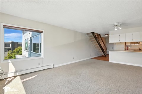 A spacious living room with a staircase leading to the upper floor.