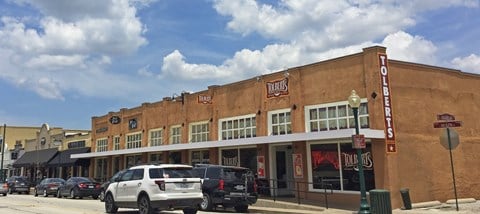 a large brown building with cars parked in front of it