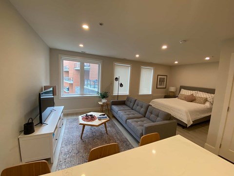 a bedroom and living room with a couch and a table