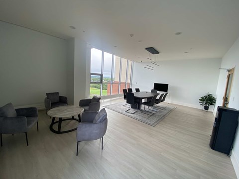 a room with a table and chairs and a large window