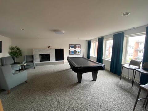a living room with a pool table in the middle