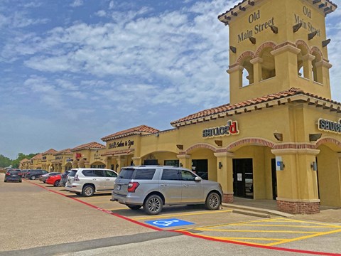 a parking lot in front of a shopping center with cars parked