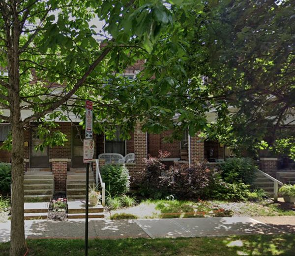 a red brick building with a tree in front of it