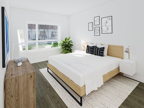 A bedroom with a large bed, a wooden nightstand, and a plant.