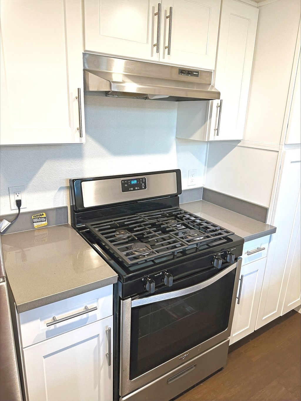 a kitchen with white cabinets and a stove and a microwave