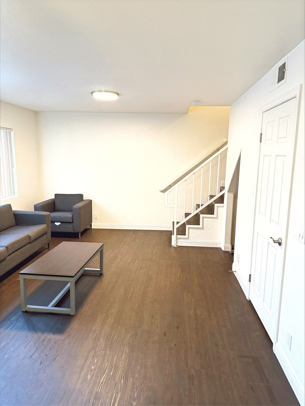 an empty living room with a couch and a table