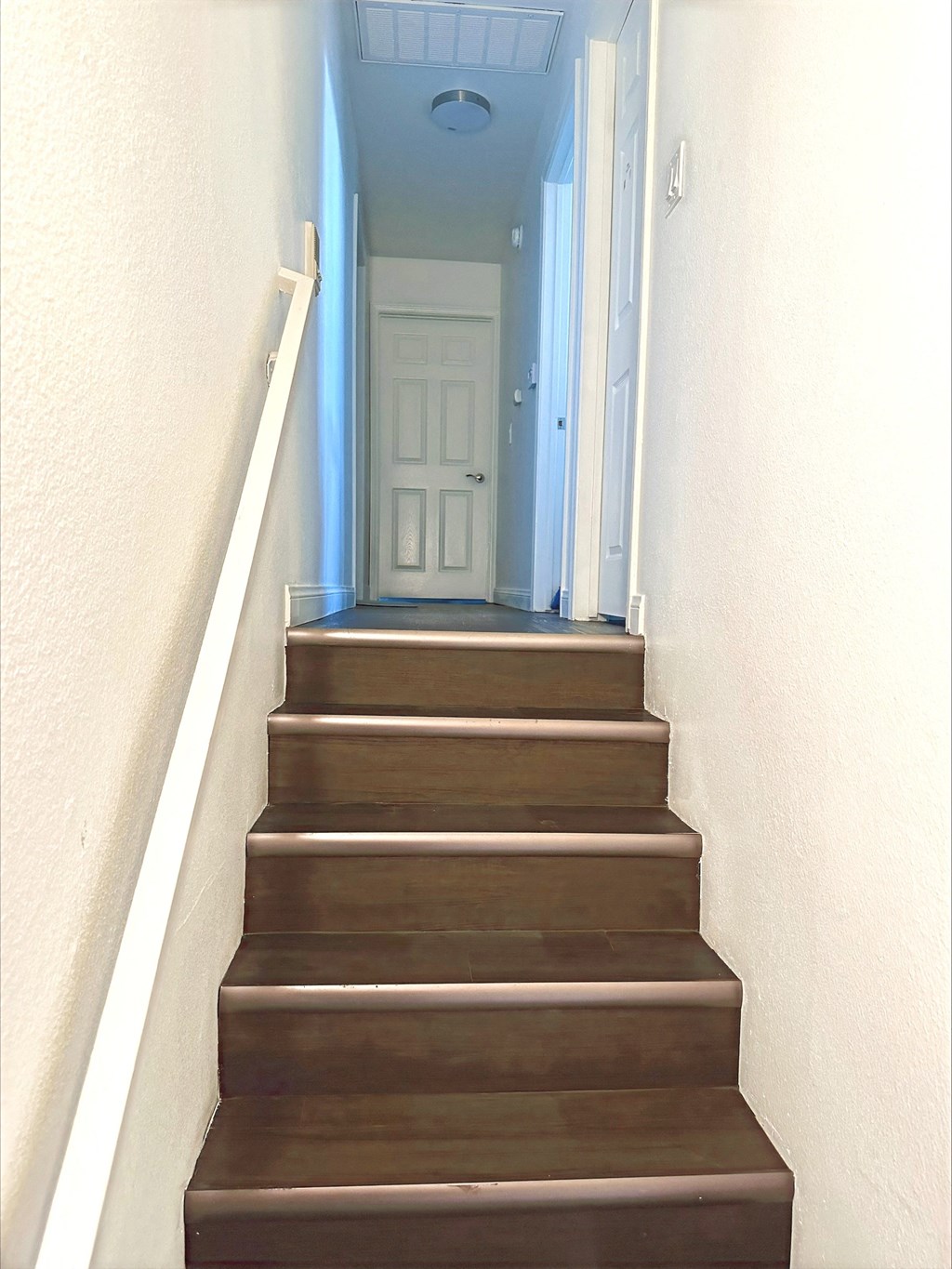 a set of wooden stairs leading up to a white door