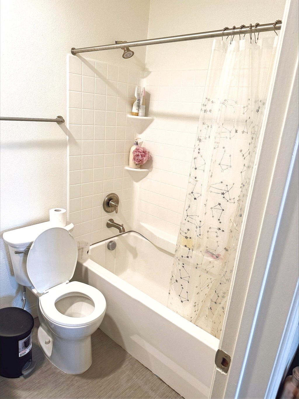 a bathroom with a toilet and a tub and a shower curtain