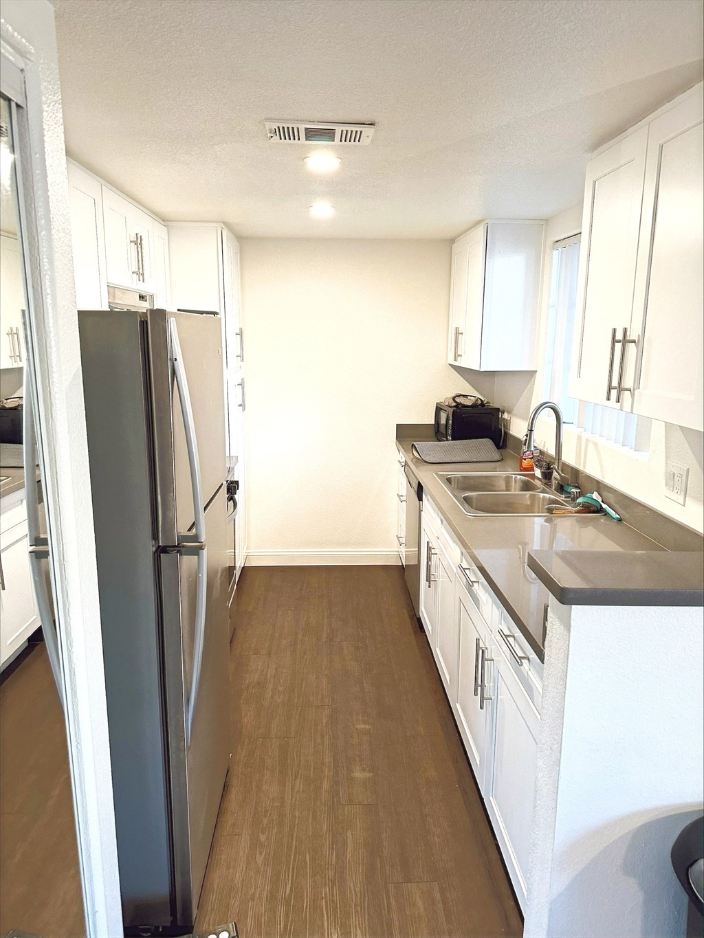 a kitchen with white cabinets and stainless steel appliances