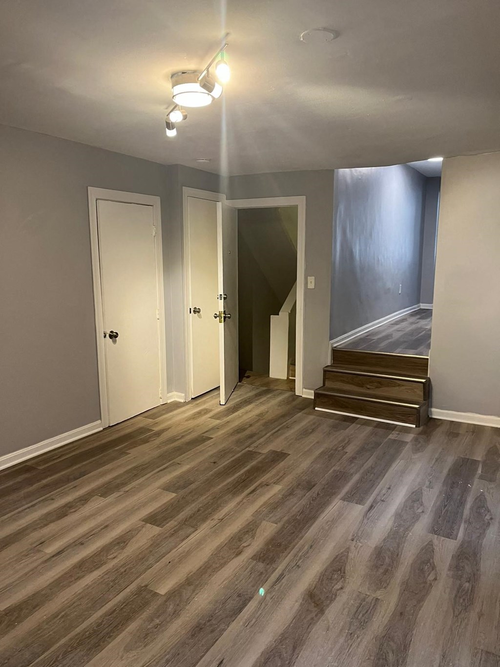 a renovated living room with wood floors and a staircase