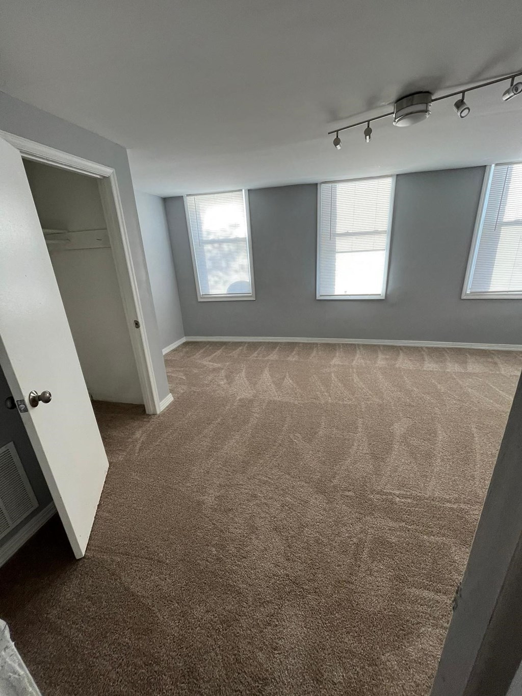 an empty room with three windows and a door