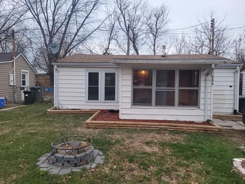 a small white tiny house in a backyard with a patio