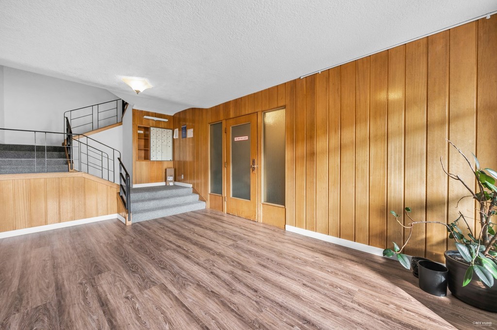 A room with wooden walls and a staircase.