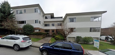 an apartment building with cars parked in front of it