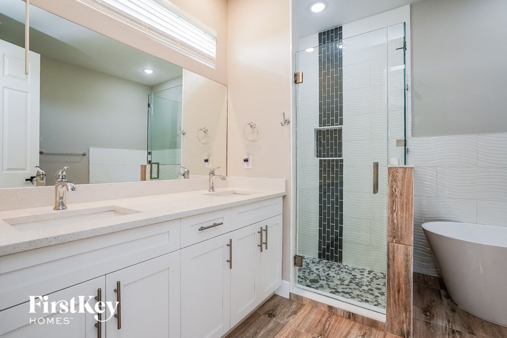 A bathroom with a white tub and a glass shower door.