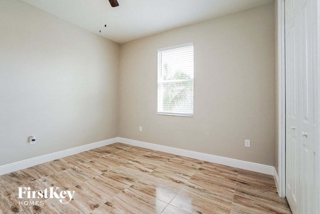 A room with wooden flooring and a window letting in light.