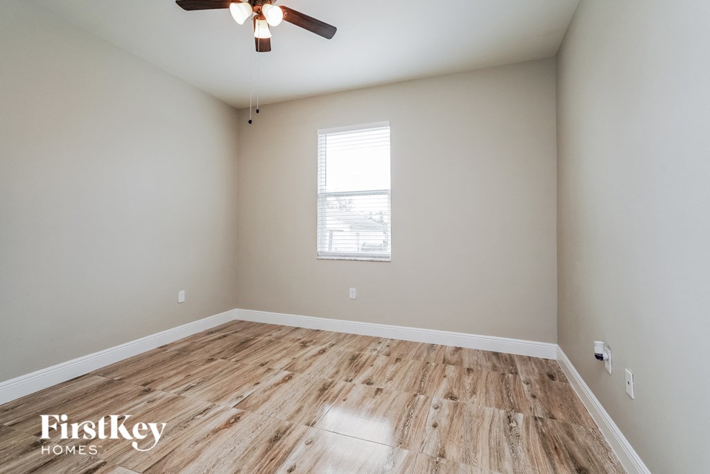 A room with wooden flooring and a ceiling fan.