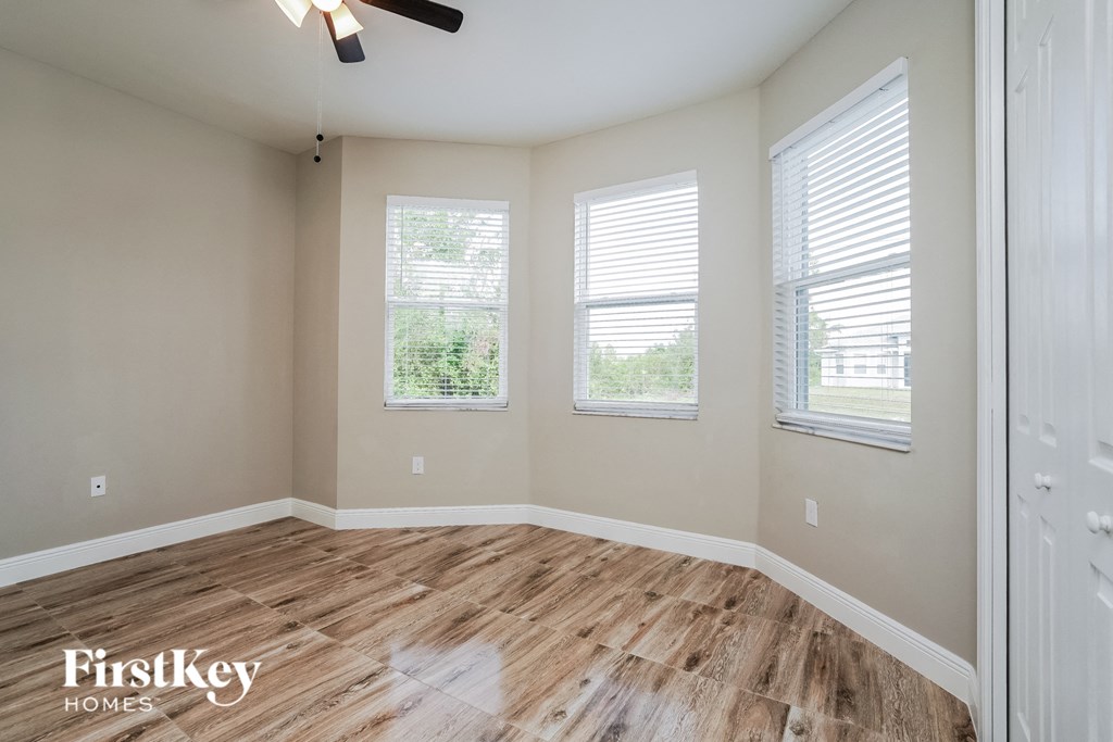 A room with wooden flooring and a ceiling fan.