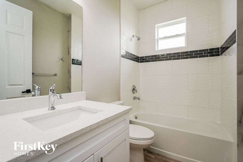 A white bathroom with a sink, toilet, and bathtub.