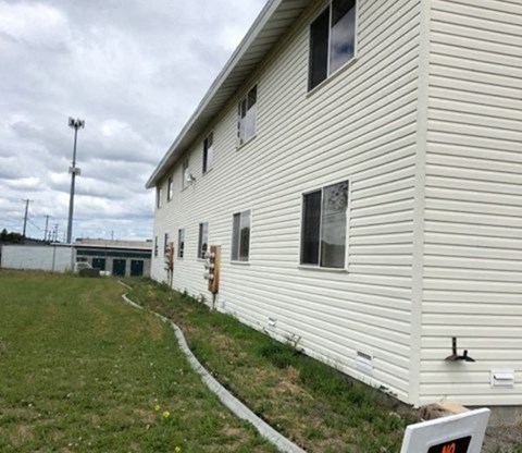 A white building with a sign in front of it.