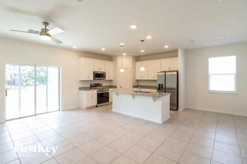 A spacious kitchen with white cabinets and appliances.