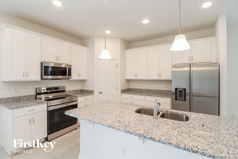 A kitchen with granite countertops and stainless steel appliances.