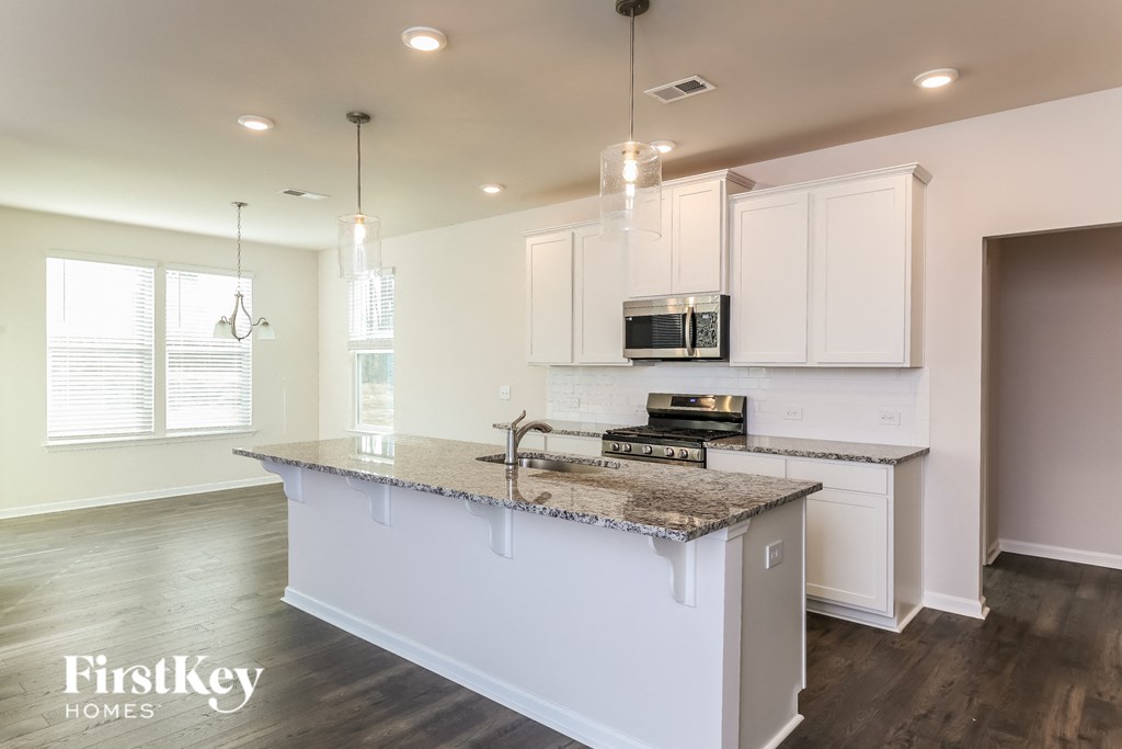 A kitchen with a granite countertop and white cabinets.