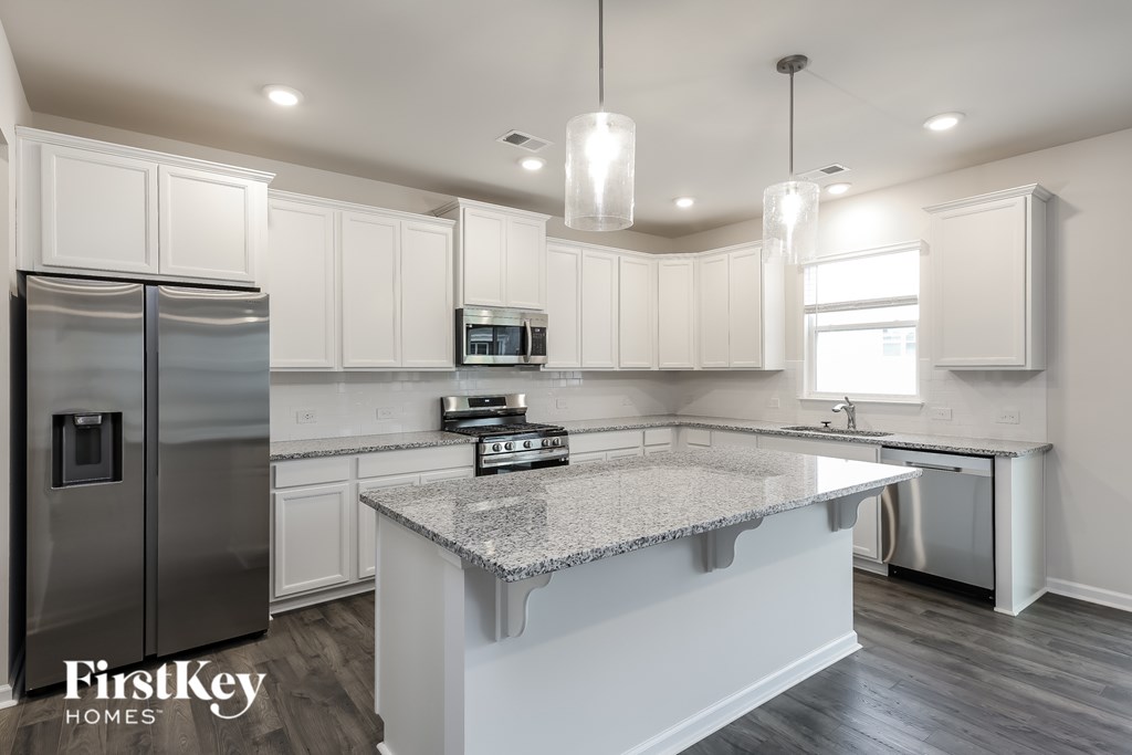 A kitchen with a granite countertop and a refrigerator.